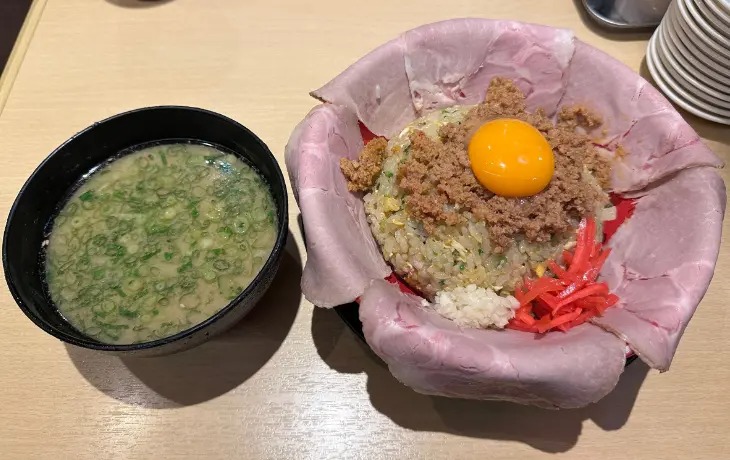 「モヒカンらーめん 博多デイトス店」のチャーシューと卵黄がのった名物炒飯