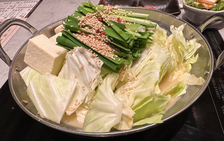 福岡・博多名物「博多もつ鍋 おおやま」のニラとキャベツ、豆腐がたっぷり乗ったもつ鍋。