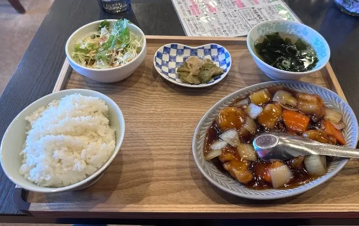 福岡の中華料理店「宇宙軒」の具だくさんな酢豚定食(ご飯、サラダ、スープ、小鉢付き)。