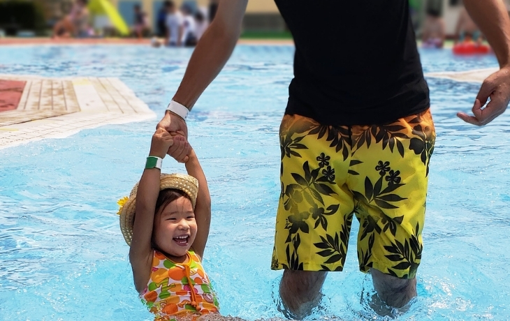 健康の森公園市民プールの屋外プールで水遊びを楽しむ親子(イメージ)
