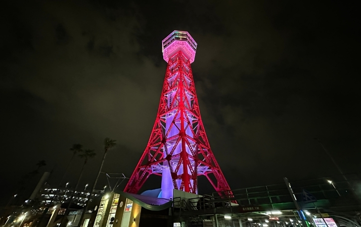 レインボーカラーにライトアップされた夜の博多ポートタワーの外観